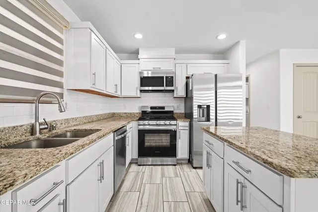 a kitchen with a refrigerator a sink and dishwasher with wooden floor