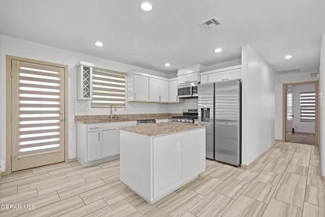 a kitchen with granite countertop white cabinets and white appliances
