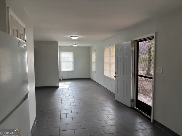 a view of a hallway with wooden floor and a bathroom