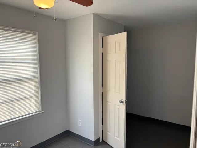 a view of an empty room with window and wooden floor