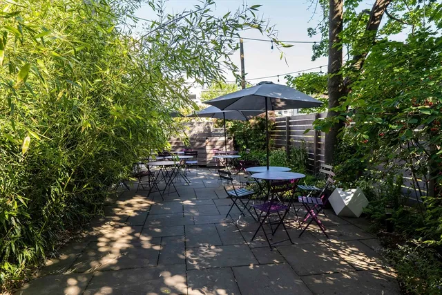 a view of a patio with table and chairs under an umbrella