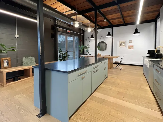 a large room with kitchen island a large counter space a sink and stainless steel appliances