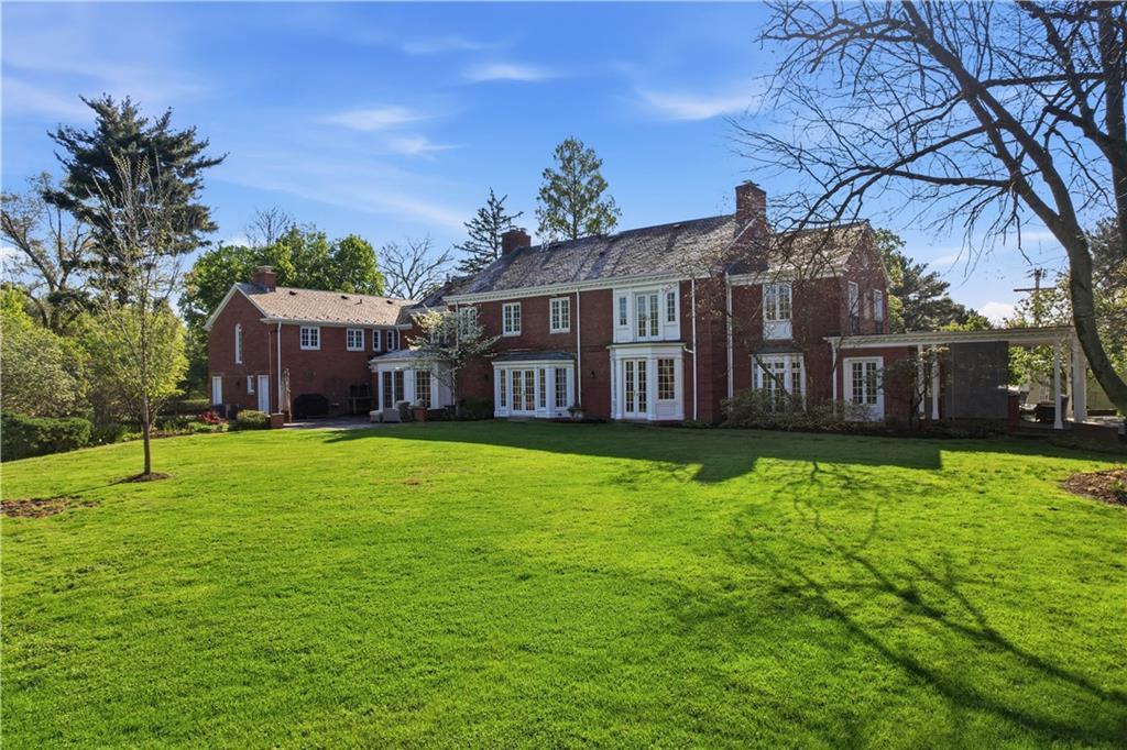 600 Backbone Road Sewickley, PA 15143 - Photo 6 of 50 The rear elevation reveals expansive lawn space and a graceful connection to the home’s outdoor living areas. It is a setting that feels private, open, and beautifully maintained.