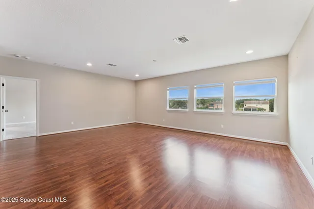 an empty room with a window and a ceiling fan