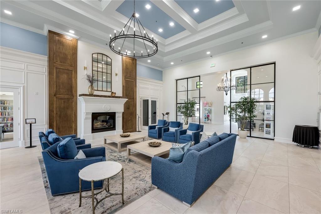 3108 Dominica Way Naples, FL 34119 - Photo 27 of 39 Spacious common area featuring a coffered ceiling, a substantial fireplace with a white mantel, and large black-framed glass partitions