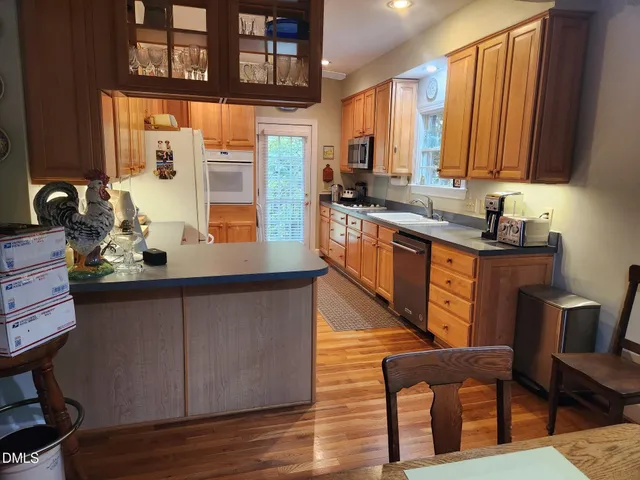 a kitchen with stainless steel appliances granite countertop a sink table and chairs