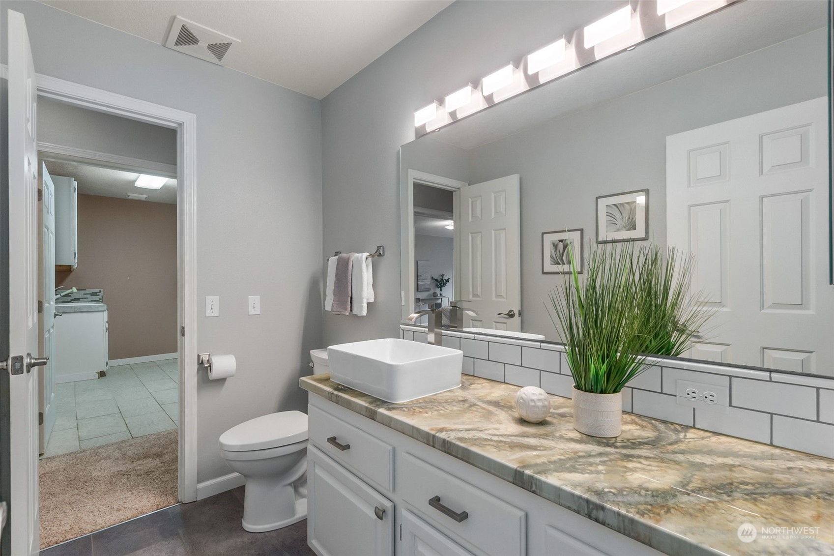 8019 68th Loop Southeast Olympia, WA 98513 - Photo 29 of 40 a bathroom with a granite countertop sink a toilet and mirror