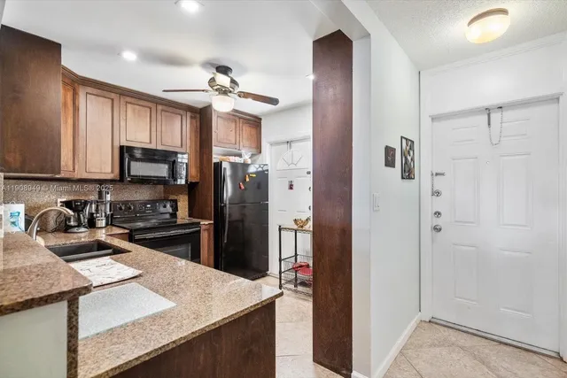 a kitchen with kitchen island granite countertop stainless steel appliances and a refrigerator