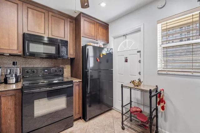 a kitchen with stainless steel appliances granite countertop a refrigerator stove and sink