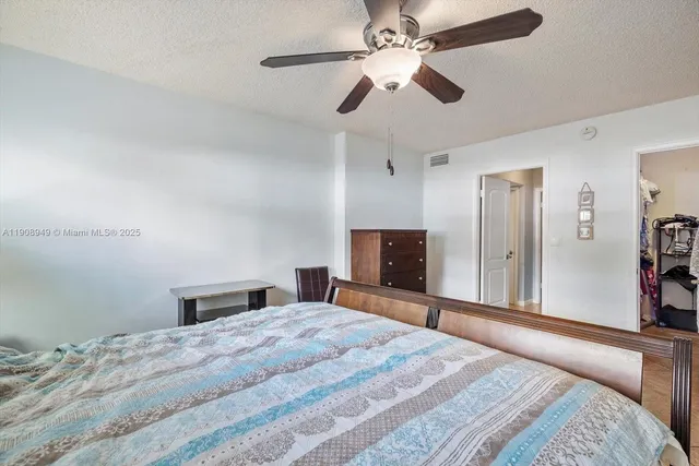 a bedroom with a large bed and a chandelier