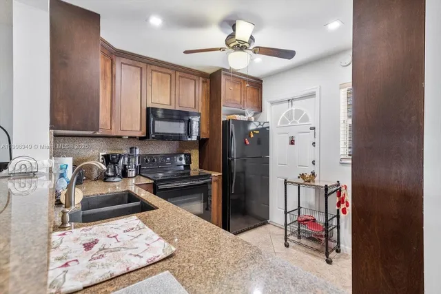 a kitchen with stainless steel appliances granite countertop a refrigerator stove top oven a sink and dishwasher