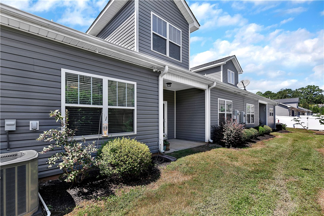 121 Ventura Street Anderson, SC 29621 - Photo 26 of 32 A welcoming rear facade features neatly trimmed shrubs and a tidy lawn, offering a private outdoor space.