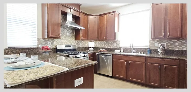 a bathroom with a granite countertop sink a toilet and a shower