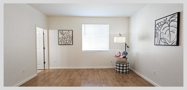 a view of a room with wooden floor and a bathroom