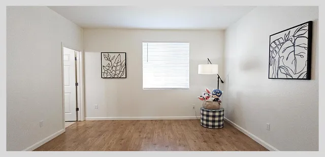 a view of a room with wooden floor and a bathroom