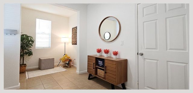 a swimming pool with outdoor seating and trees in the background