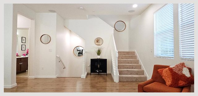 a living room with furniture and two large window
