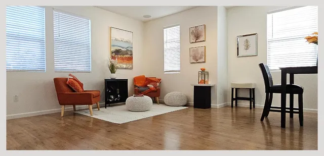 a living room with furniture a chandelier and a dining table