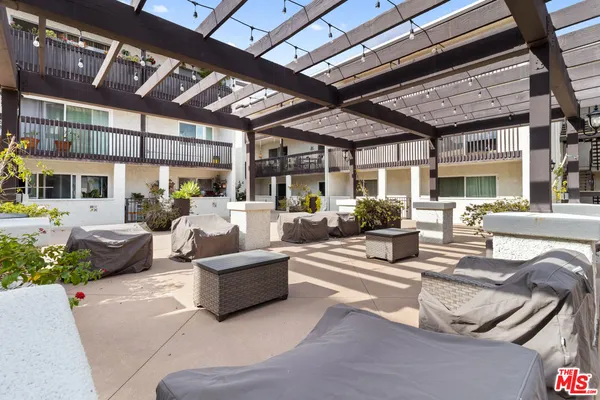 a living room with patio furniture and a ceiling fan