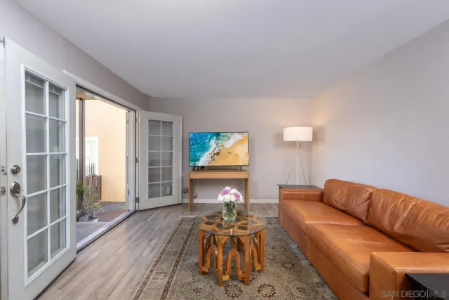 a living room with furniture a dining table and a large window