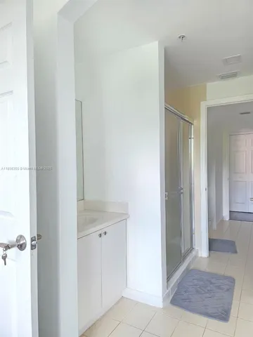 a view of a hallway with closet and a bathroom