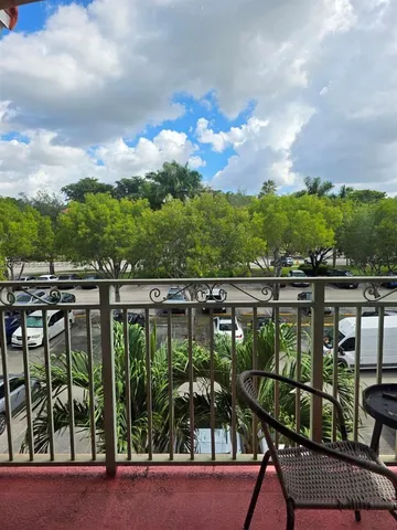 a view of a balcony with wooden chairs and city view