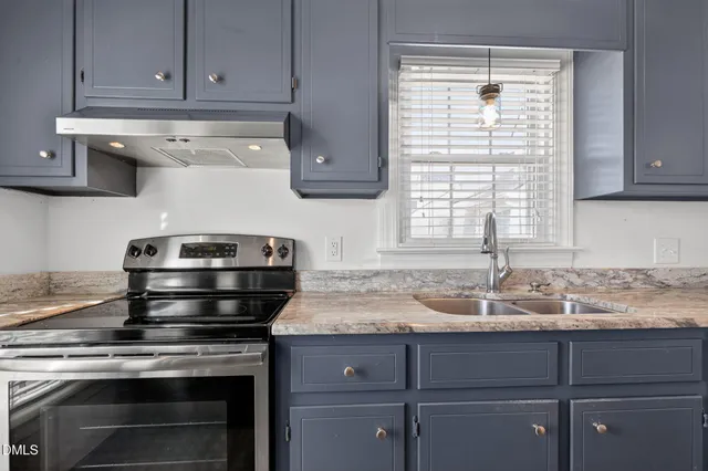 a kitchen with granite countertop cabinets stainless steel appliances and a sink