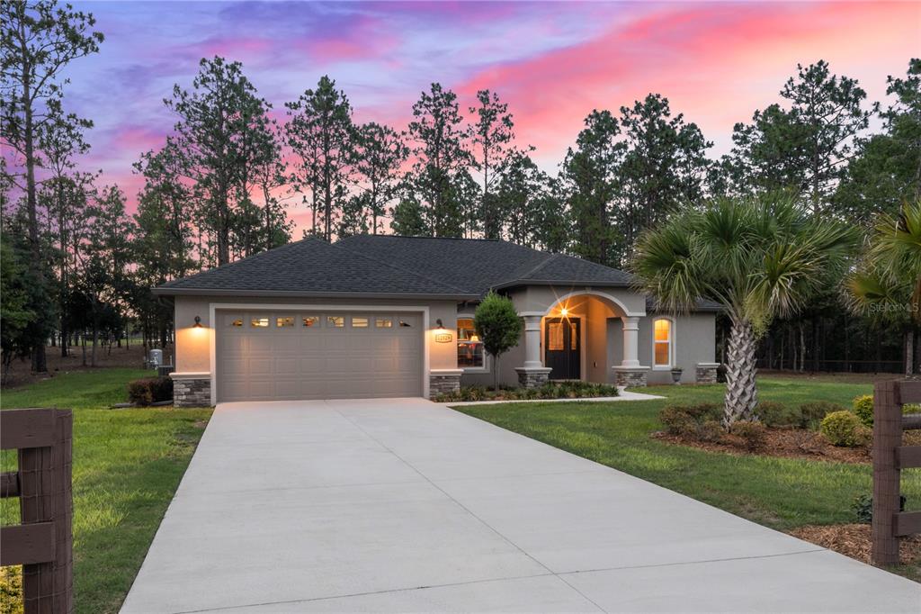 12929 Southwest 89th Street Dunnellon, FL 34432 - Photo 44 of 76 a front view of a house with a yard and trees
