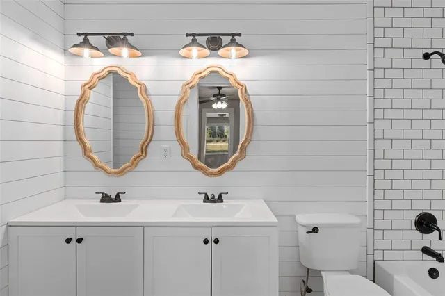 a bathroom with a sink mirror vanity and toilet