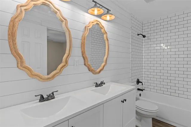 a bathroom with a sink a toilet and a mirror