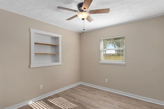 an empty room with a window and a fan