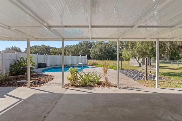 a view of a patio with table and chairs under an umbrella