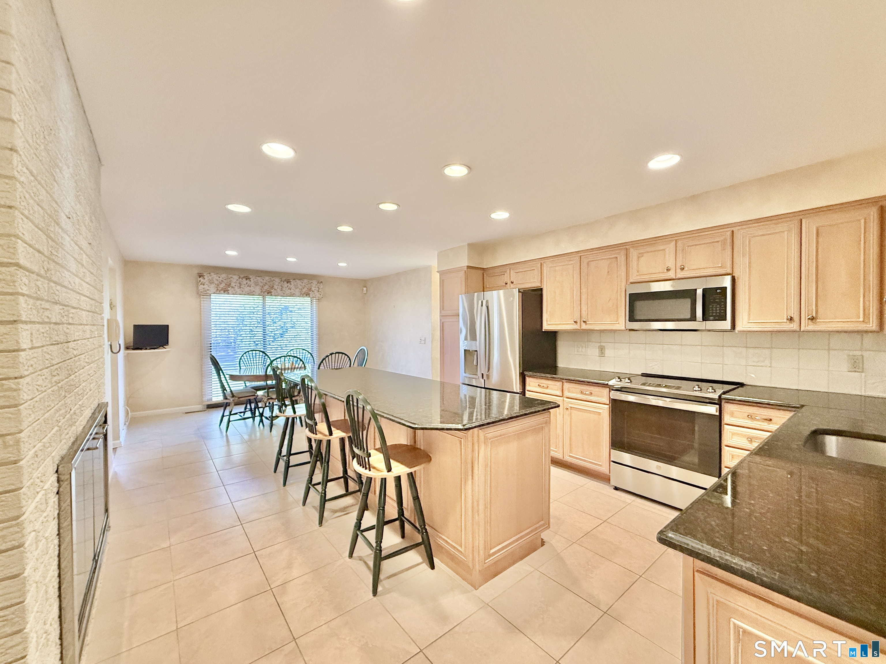 1 Alfred Lane Stamford, CT 06902 - Photo 17 of 35 a kitchen with stainless steel appliances kitchen island granite countertop a stove a sink a dining table and chairs with the cabinets