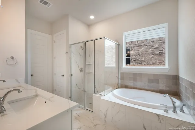 a spacious bathroom with a double vanity sink mirror double and shower