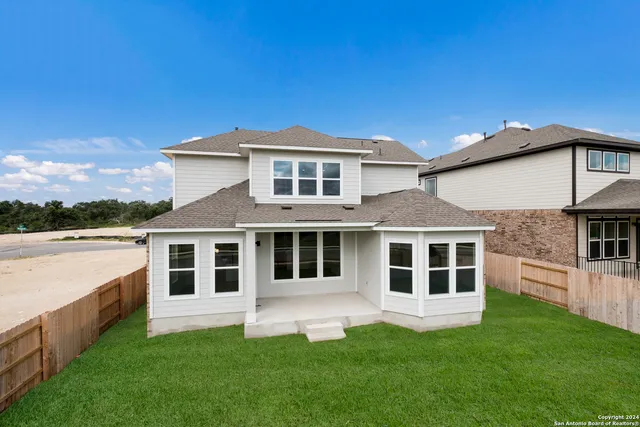 a view of a swimming pool with lawn chairs and a big yard
