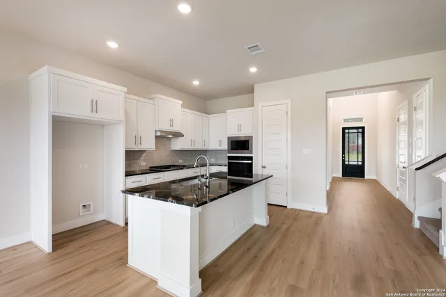 a kitchen with granite countertop a sink and wooden floor
