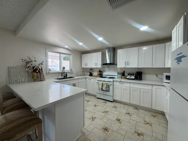 a kitchen with granite countertop cabinets a sink a counter top space and stainless steel appliances