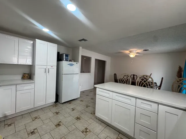 a kitchen with a sink a refrigerator and cabinets