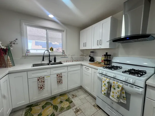 a kitchen with stainless steel appliances granite countertop a sink stove and cabinets
