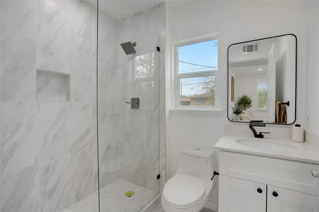 a bathroom with a sink a toilet and shower