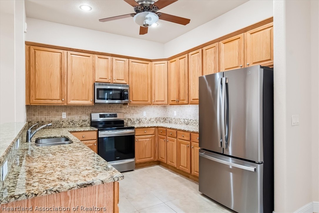 5224 Haw Branch Road Sebring, FL 33875 - Photo 3 of 40 a kitchen with granite countertop stainless steel appliances a refrigerator sink and microwave