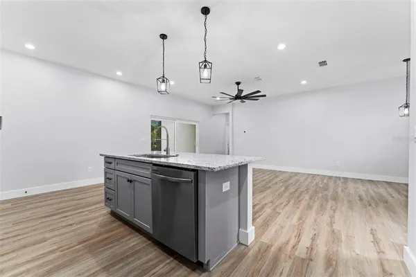 a kitchen with kitchen island a sink and wooden floor
