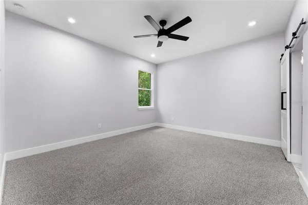 an empty room with a window and a ceiling fan