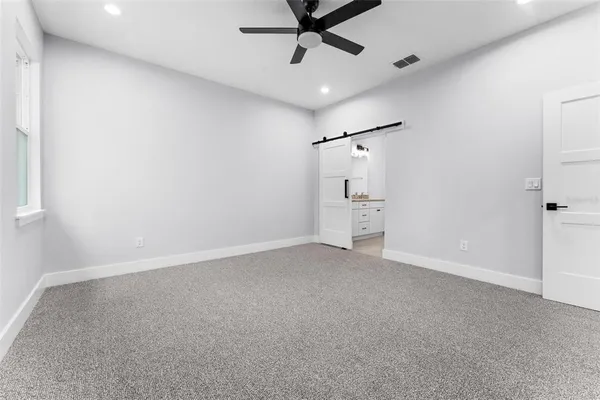 an empty room with a ceiling fan and window
