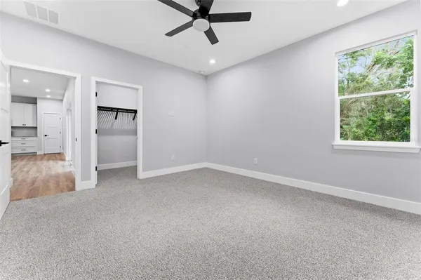 an empty room with a window and a ceiling fan
