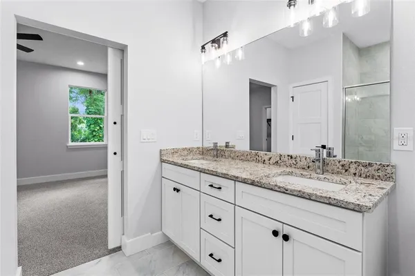 a bathroom with a granite countertop sink and a mirror