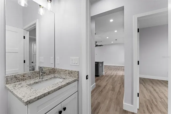 a bathroom with a granite countertop sink and a mirror