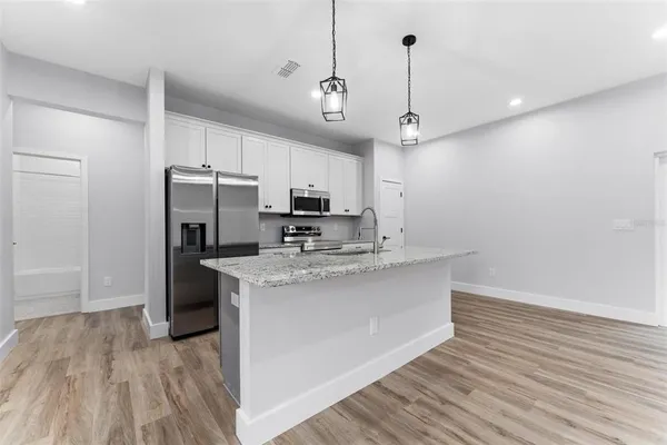 a kitchen with kitchen island a sink stainless steel appliances and cabinets