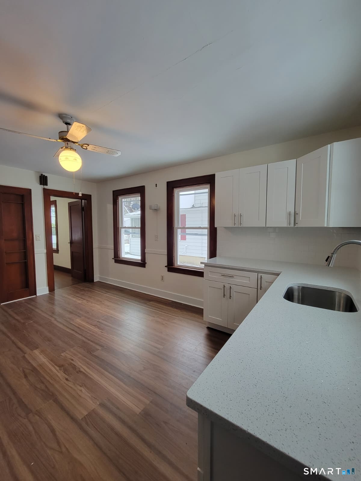 a view of a kitchen with furniture and wooden floor