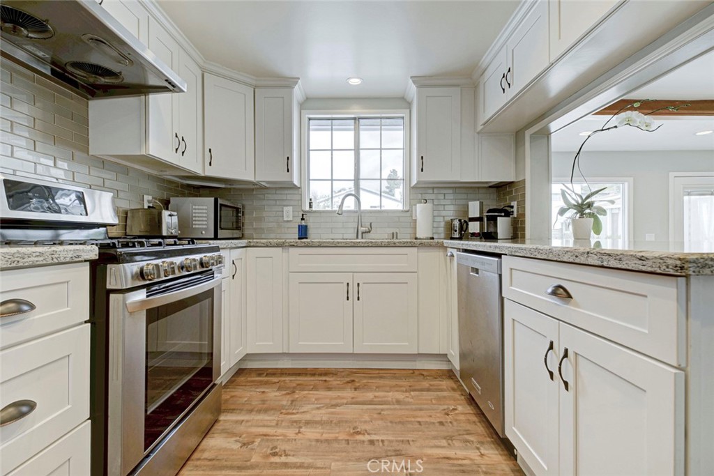 6911 Valmont Street Tujunga, CA 91042 - Photo 22 of 55 a kitchen with white cabinets appliances and a sink